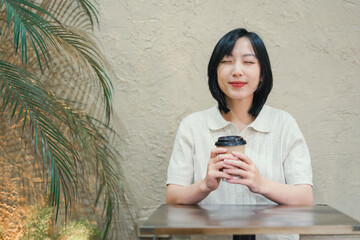 Relaxed woman enjoying coffee in a cozy cafe with a warm atmosphere in the afternoon