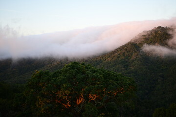 Blanket of fog rolling over a mountain ridge at sunrise