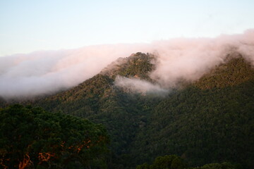 Blanket of fog rolling over a mountain ridge at sunrise