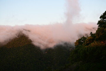 Blanket of fog rolling over a mountain ridge at sunrise