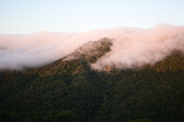 Blanket of fog rolling over a mountain ridge at sunrise