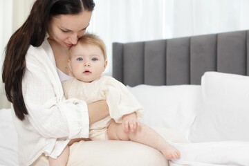 Mother with her little baby on bed indoors