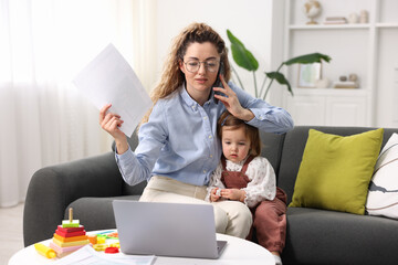 Work-family balance. Single mother with document talking on smartphone and her daughter indoors