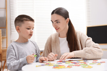 Dyslexia. Mother and her son learning letters at table indoors