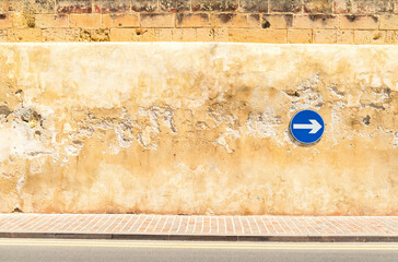 Cracked wall with a safety sign on it, proceed right only
