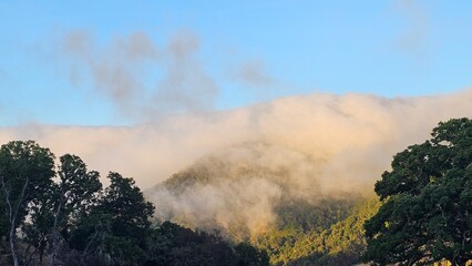 Blanket of fog rolling over a mountain ridge at sunrise