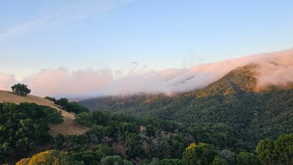Blanket of fog rolling over a mountain ridge at sunrise