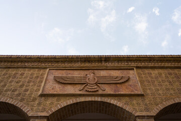 Zoroastrian fire temple in Yazd, Iran, featuring the iconic Faravahar symbol, intricate masonry, and rich Persian heritage under a clear sky.