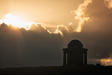 Sunset behind Brightling temple on the high weald east Sussex south east England UK