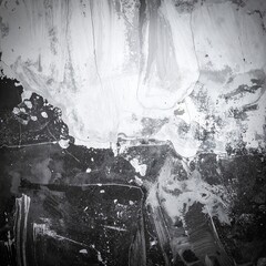 A striking black and white photograph showcasing textured paint splatters on a weathered wall, highlighting the contrast between light and shadow.