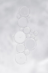 Transparent skincare serum texture with air bubbles on light background