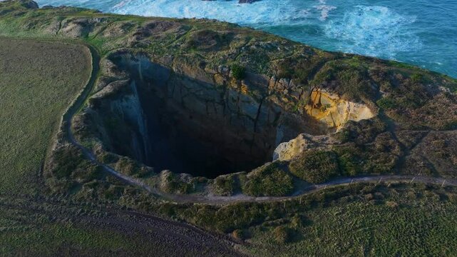 Aerial drone view of the Sima de Liencres and the Urro del Manzano in the Dunes of Liencres Natural Park. Pi&eacute;lagos Municipality, Costa Quebrada Geopark, Cantabrian Sea, Cantabria, Spain, Europe