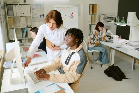 Diverse group of students working collaboratively in lab setting with computer and lab equipment