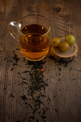  a glass of green tea, loose tea leaves, and fresh green grapes on rustic wood, evoking a sense of natural wellness and delightful simplicity. Ideal for health blogs, beverage industry content