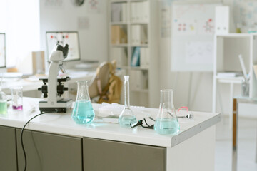 Modern laboratory equipped with microscopes, beakers, and various research tools. Organized workspace highlighting focus on scientific study and experimentation