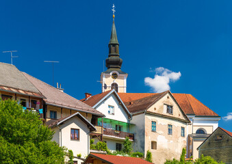 View of old residential houses in front of the Parish Church of St. Nicholas in Metlika, Slovenia