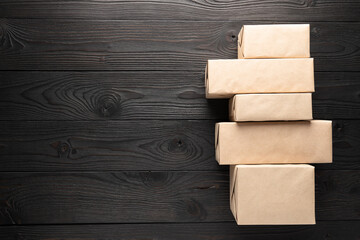 Gift Boxes Wrapped in Kraft Paper on Dark Wooden Background with Copy Space
