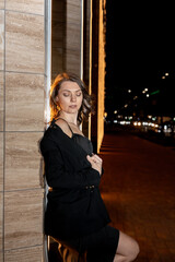 A girl in a night city, a beautiful young girl walks through the night city in an evening dress and heels