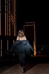 a girl in a night city, a beautiful young girl walking around the night city in an evening dress and heels, blurred photo in out of focus.