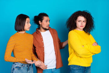 Three diverse young friends in casual clothing engaged in a lighthearted discussion against a...