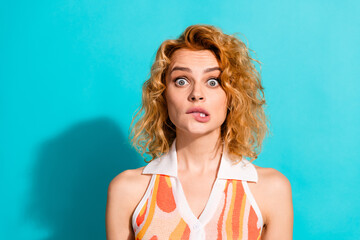 Confused young woman making a funny expression against a blue background, showing her quirky side