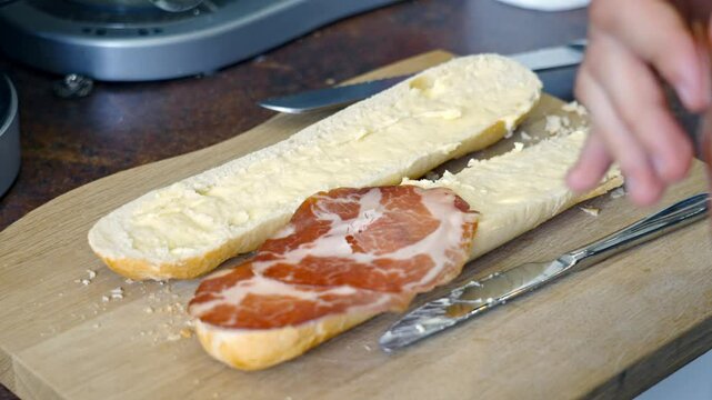 Close Up Shot Placing Italian Coppa Cured Pork Into A Baguette