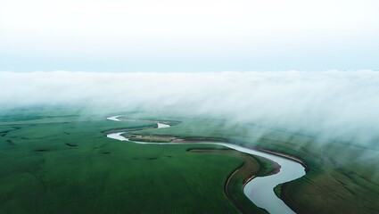 Serene River Winding Through Misty Green Fields An Aerial View
