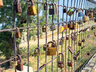 Love lock. Rusty padlocks on metal fence grid, closeup. Love and commitment concept