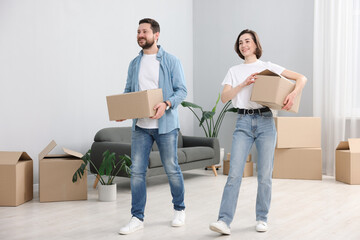 Moving day. Happy couple with cardboard boxes in their new home
