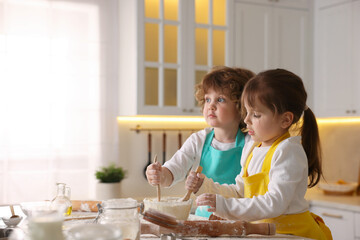 Cooking recipe. Cute children mixing dough for cookies at table in kitchen. Space for text