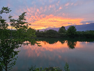 Beautiful sunset reflection over a calm lake surrounded by trees in Lake Kerkini National Park