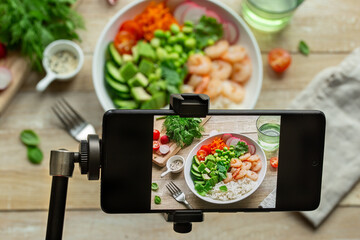 Smartphone on tripod, taking photo  of lunch bowl or salad.