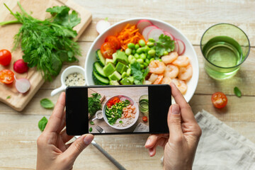 Woman hands take mobile photo of lunch bowl.