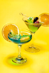 Deux verres de cocktails sur fond jaune