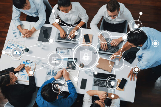 A group of professionals engages in a collaborative meeting, focusing on technology and security strategies while analyzing data visualizations in a modern office setup. Amity
