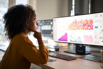 Black marketing analyst interpreting user behavior data on an insights dashboard, adjusting view filters