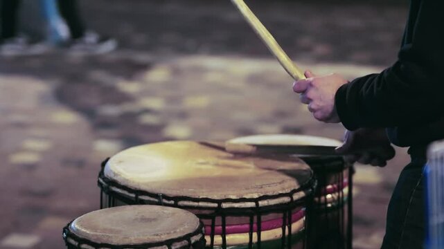 Percussionist playing a rudimentary atabaque during afro-brazilian capoeira fight presentation in the streets of Athens at Monastiraki square in Greece. Slow motion