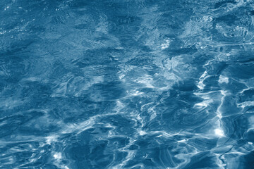 Fototapeta premium Abstract top view of dark blue water surface with gentle ripples
