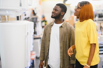 Obraz premium Happy african american young man and woman buying new heating water boiler