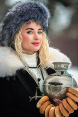 Portrait of a young beautiful blonde model-looking girl in winter clothes and a fur hat in winter.