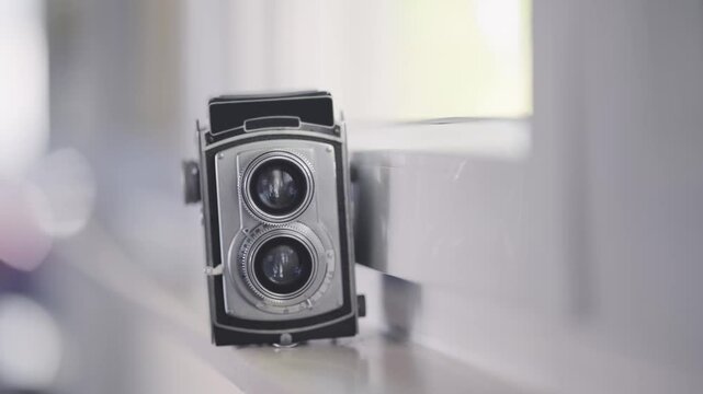 Vintage twin-lens retro reflex camera resting on a light-colored surface indoors