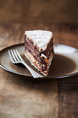 Piece of chocolate cake on rustic background. Close up.