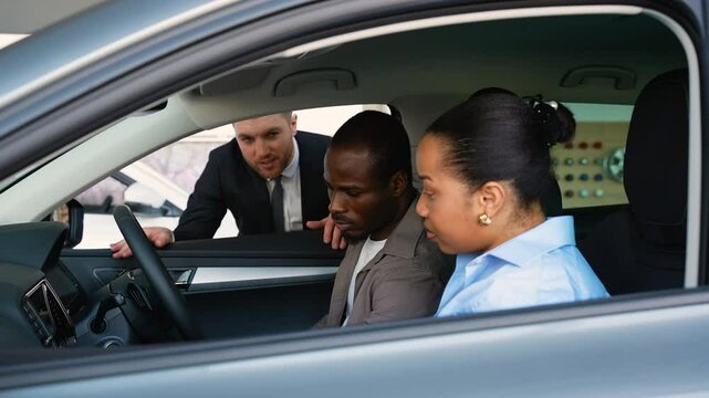 Couple choosing new car with consultant in dealership