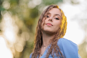 Obraz premium Beautiful Girl with long hair posing in sunbeams in park