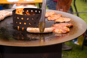 Outdoor barbecue with sausages and steaks on a grill