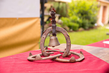 Rustic horseshoe bell centerpiece on red fabric at outdoor event