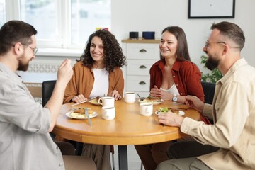 Colleagues chatting during lunch break in office