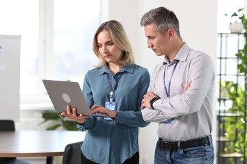 Engineers working together with laptop in office