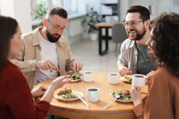 Colleagues chatting during lunch break in office