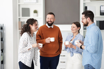 Colleagues chatting during coffee break in office